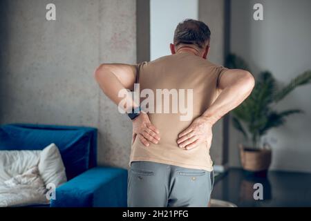 Un homme qui a des douleurs dans le bas du dos Banque D'Images