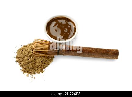 Bol avec thé vert hojicha, poudre et chasen sur fond blanc Banque D'Images