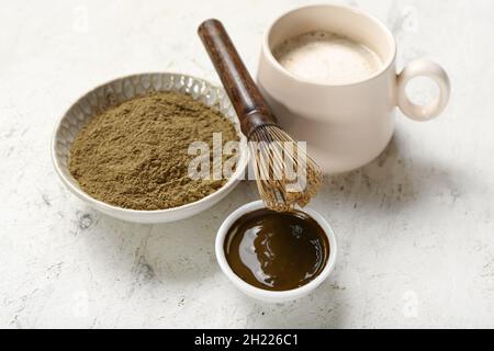 Bol avec poudre de hojicha, tasse de thé et chasen sur fond clair Banque D'Images
