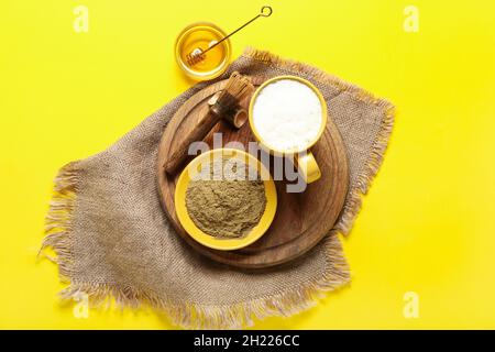 Bol avec poudre de hojicha, miel, tasse de thé et chasen sur fond jaune Banque D'Images