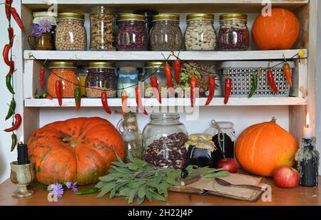 Cuisine vintage encore vie avec des haricots secs dans des bouteilles de verre, le poivre sec, les légumes frais, la citrouille.Provence, style rural Banque D'Images