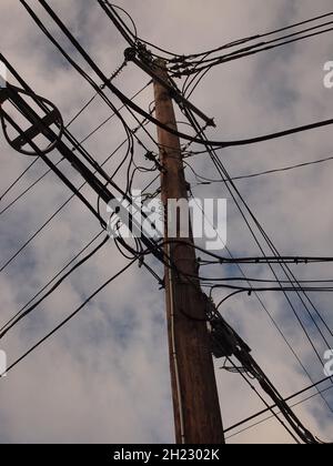 Poteaux électriques avec de nombreux câbles et fils attachés. Apparemment une bande de fils emmêlée. Banque D'Images