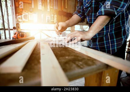 gros plan menuisier homme travaillant et mesurer le bois dans l'atelier Banque D'Images