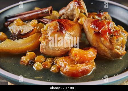 Cuisses de poulet caramélisées au miel, aux raisins secs, aux pommes et aux poires.Cuisine gastronomique française Banque D'Images