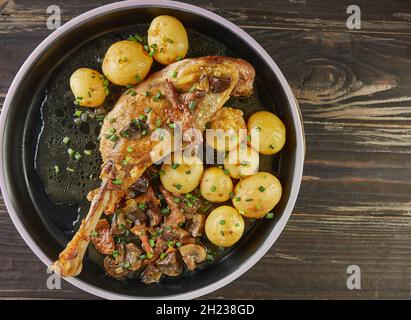 Queues d'oie avec portobello et champignons de la forêt cuits avec de nouvelles pommes de terre et armagnac.Cuisine gastronomique française Banque D'Images