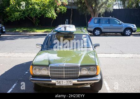 Mercedes Benz 300 TD classique break ou station wagon avec une planche de surf sur le toit, Sydney Street, NSW, Australie Banque D'Images