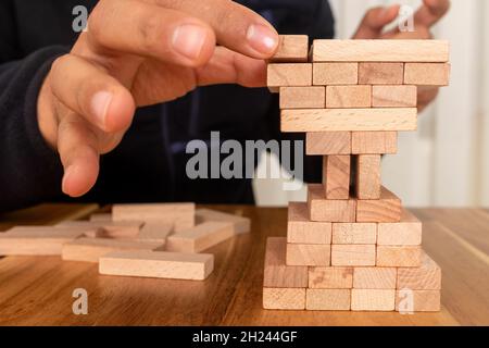 Homme construction de blocs de bois de forme sablier.Concept de gestion des affaires et du temps. Banque D'Images