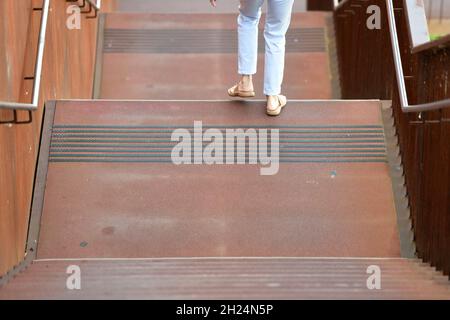 Eine Frau in sommerlicher Kleidung geht auf einer rostigen Stiege aus Stahl hinunter, Österreich, europa - Une femme en vêtements d'été descend une rouille Banque D'Images