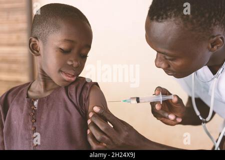 Dans cette image, un tout-petit noir reçoit son premier vaccin antipaludique dans un petit dispensaire de la communauté rurale africaine Banque D'Images