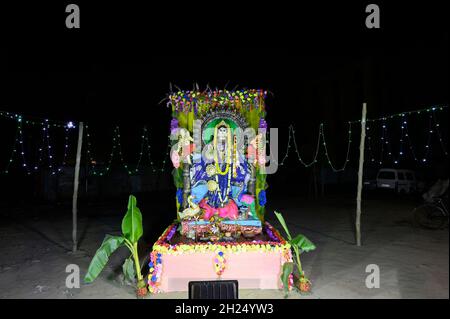 Idole de la déesse Saraswati étant adorée la nuit. Lumière colorée sur la déesse hindoue. Howrah, Bengale-Occidental, Inde. Banque D'Images