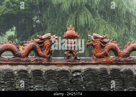 Dragons en céramique faisant face à la perle de la sagesse sur une crête de toit dans l'ancienne ville de Furong, en Chine. Banque D'Images