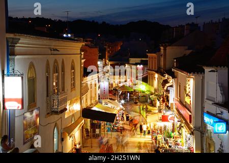 Portrait de la R 5 de Outubro shopping street dans la soirée avec les touristes appréciant les paramètre, Albufeira, Portugal, Europe. Banque D'Images