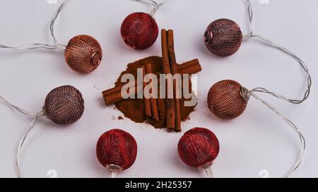 Petit râpe avec bâtonnets de cannelle et poudre, isolé sur un fond blanc entouré de boules de Noël Banque D'Images