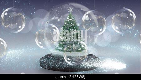 Image d'un globe de neige avec un sapin de noël sur une décoration de boules de noël Banque D'Images
