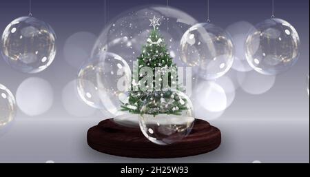 Image d'un globe de neige avec un sapin de noël sur une décoration de boules de noël Banque D'Images