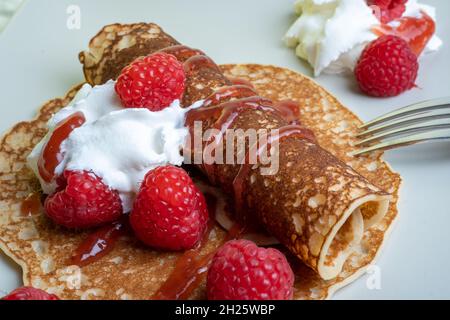 Helsinki / Finlande - 20 OCTOBRE 2021 : cuisine finlandaise traditionnelle : crêpes finlandaises sur une assiette avec crème fouettée et confiture de framboises sur le côté Banque D'Images