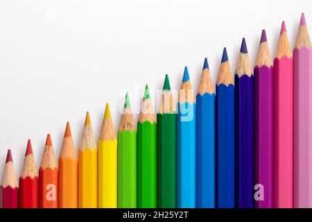 Crayons de couleur disposés en diagonale sur un fond de papier blanc. Banque D'Images