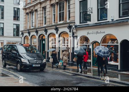 Londres, Royaume-Uni - 02 octobre 2021 : personnes avec parapluie marchant sous la pluie sur Jermyn Street, connue comme une rue pour les gentlemen-habillement détaillants, la taxe Banque D'Images