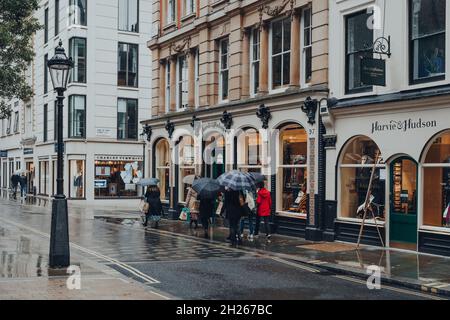 Londres, Royaume-Uni - 02 octobre 2021 : les femmes marchent à côté de Harvie et Hudson, une boutique pour hommes vendant des costumes, cravates, chemises habillées et accessoires classiques, sur un Banque D'Images