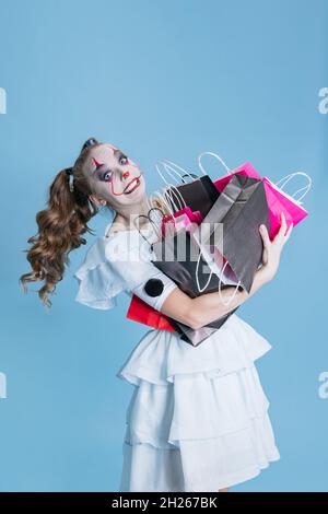 Jeune fille à l'image de Dancing Clown avec des magasins de maquillage lumineux.Fêtez Halloween et le vendredi noir Banque D'Images
