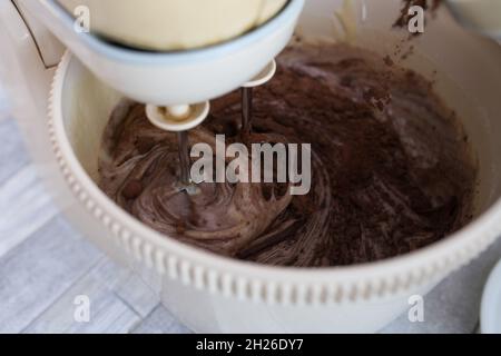 Processus étape par étape de fabrication d'un gâteau au chocolat à la crème aigre.Battez la pâte avec du cacao dans un bol mélangeur.Concept de cuisson. Banque D'Images