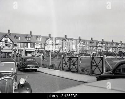 Années 1950, historique, parade de magasins et terrain de jeu, sud-est de Londres, Angleterre, Royaume-Uni, avec des voitures de l'époque garées à côté.Peut-être Abbey Wood ou Eltham. Banque D'Images