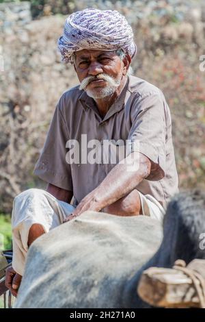 RANAKPUR, INDE - 13 FÉVRIER 2017 : un homme local travaille à une pompe à chaîne, État du Rajasthan, Inde Banque D'Images