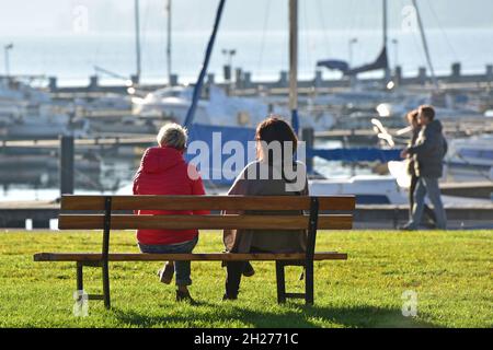 Herbstmunstimg am Attersee, zwei Frauen suchen BEI sonnigem Wetter Erholung auf einer Bank - l'humeur d'automne à l'Attersee, deux femmes cherchent à re Banque D'Images