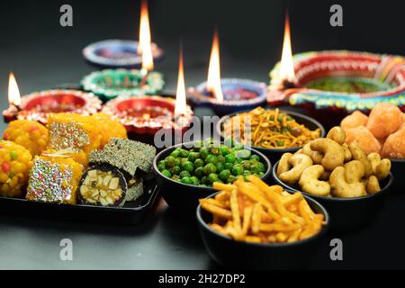 En-cas salés croustillants Masala Namkeen et doux mithai comme Meetha Anjeer Roll, Moti Pak Burfi et Diya Deep ou Dia illuminé.Thème pour Navratri Pooj Banque D'Images