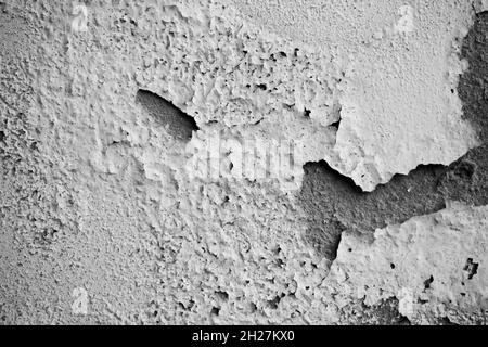 Mur blanc humide présentant des fissures de peinture et une rupture ou un décollement.La doublure blanche fragile des murs.Résumé fissuré et gonflé noir-whi Banque D'Images