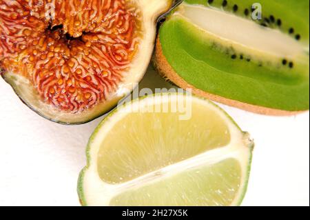 Chaux, kiwi et figues isolés sur fond blanc.Vue macro.Fruits frais d'aspect naturel.Vue de dessus, plan d'appartement. Banque D'Images