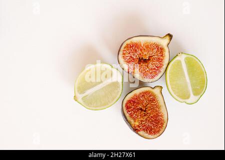 Chaux et figues isolées sur fond blanc.Fruits frais d'aspect naturel.Vue de dessus, plan d'appartement. Banque D'Images