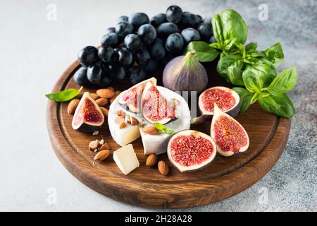 Plateau de fromages avec camembert, figues, raisins et noix.Assiette de hors-d'œuvre, encas au vin Banque D'Images