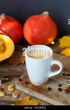 Café à la citrouille aux épices en céramique sur une table en bois avec des citrouilles d'orange et des feuilles sèches en arrière-plan.Ambiance d'automne.Temps de drin Banque D'Images