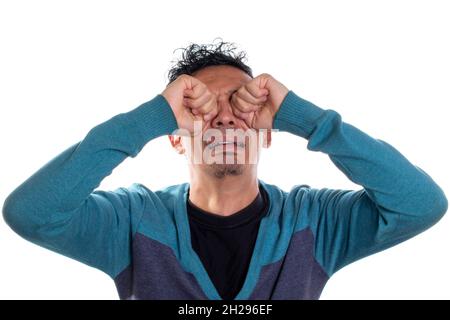 Jeune adulte jeune homme pleure, isolé sur fond blanc.Homme pleurant avec les mains sur le visage. Banque D'Images
