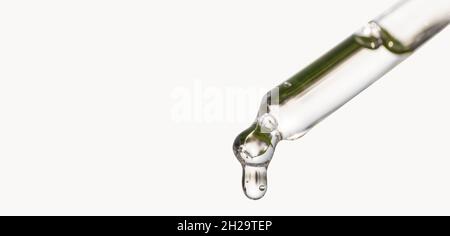 Pipette cosmétique avec goutte d'huile essentielle, sérum avec peptides, acide hyaluronique sur fond blanc.Gros plan du compte-gouttes bleu, chute de près Banque D'Images