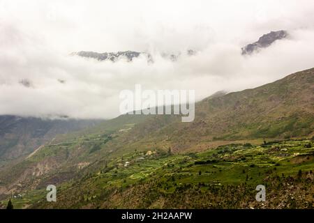 Pentes vertes d'une montagne himalayenne recouverte d'une épaisse brume Banque D'Images