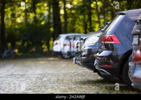 stationnement de voitures dans un parking avec pavés, entouré d'arbres Banque D'Images