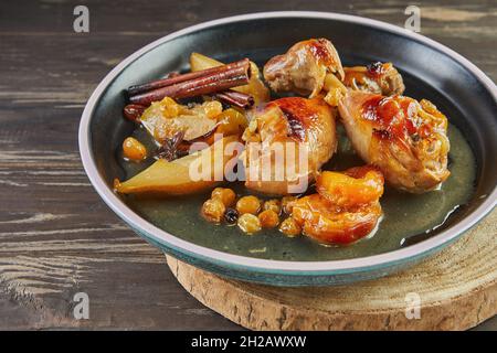 Cuisses de poulet caramélisées au miel, aux raisins secs, aux pommes et aux poires.Cuisine gastronomique française. Banque D'Images