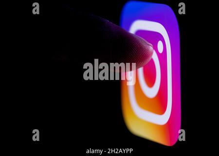 Le doigt atteint le logo du réseau social Instagram sur l'écran du smartphone. Banque D'Images