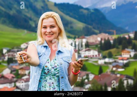 femme tenant des clés et un smartphone Banque D'Images