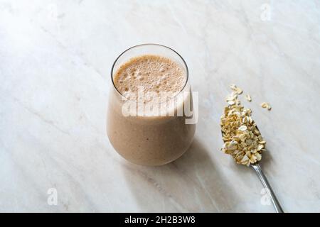 Flocons d'avoine, smoothie au beurre d'arachide, à la cannelle, à la banane et à la pomme.Boisson biologique prête à boire. Banque D'Images