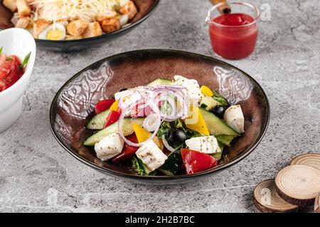 Portion de salade grecque fraîche sur fond gris Banque D'Images