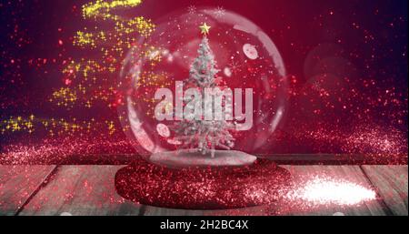 Image de chutes de neige et de taches brillantes sur le globe de neige avec arbre sur fond rouge Banque D'Images