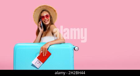 La fille de voyageur heureux tient le passeport, le billet, l'argent avec la valise appelle le taxi à l'aéroport.Concept de voyage Banque D'Images