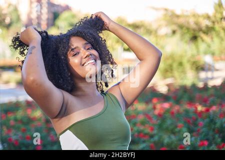 latina adolescence tirant ses cheveux bouclés avec ses mains Banque D'Images