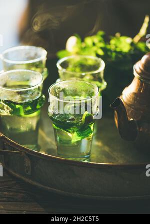 Thé marocain à la menthe fraîchement préparé avec feuilles d'herbes dans des verres Banque D'Images