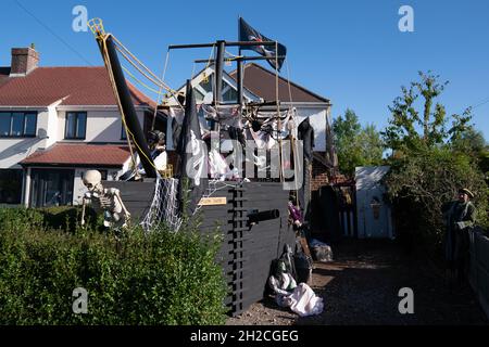 Andrew Carvel avec le bateau pirate géant « Elizabeth Dane » qu'il a construit en utilisant du bois de ferraille dans le jardin de sa maison à Tamworth, Staffordshire.Le navire mesure neuf mètres de long et est orné d'un drapeau pirate, de squelettes et de voiles sanglées, et il a fallu quelques semaines à M. Carvel pour le construire.Date de la photo: Jeudi 21 octobre 2021. Banque D'Images