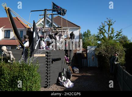 Andrew Carvel avec le bateau pirate géant « Elizabeth Dane » qu'il a construit en utilisant du bois de ferraille dans le jardin de sa maison à Tamworth, Staffordshire.Le navire mesure neuf mètres de long et est orné d'un drapeau pirate, de squelettes et de voiles sanglées, et il a fallu quelques semaines à M. Carvel pour le construire.Date de la photo: Jeudi 21 octobre 2021. Banque D'Images