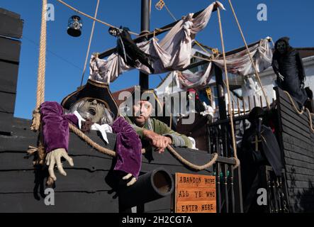 Andrew Carvel avec le bateau pirate géant « Elizabeth Dane » qu'il a construit en utilisant du bois de ferraille dans le jardin de sa maison à Tamworth, Staffordshire.Le navire mesure neuf mètres de long et est orné d'un drapeau pirate, de squelettes et de voiles sanglées, et il a fallu quelques semaines à M. Carvel pour le construire.Date de la photo: Jeudi 21 octobre 2021. Banque D'Images